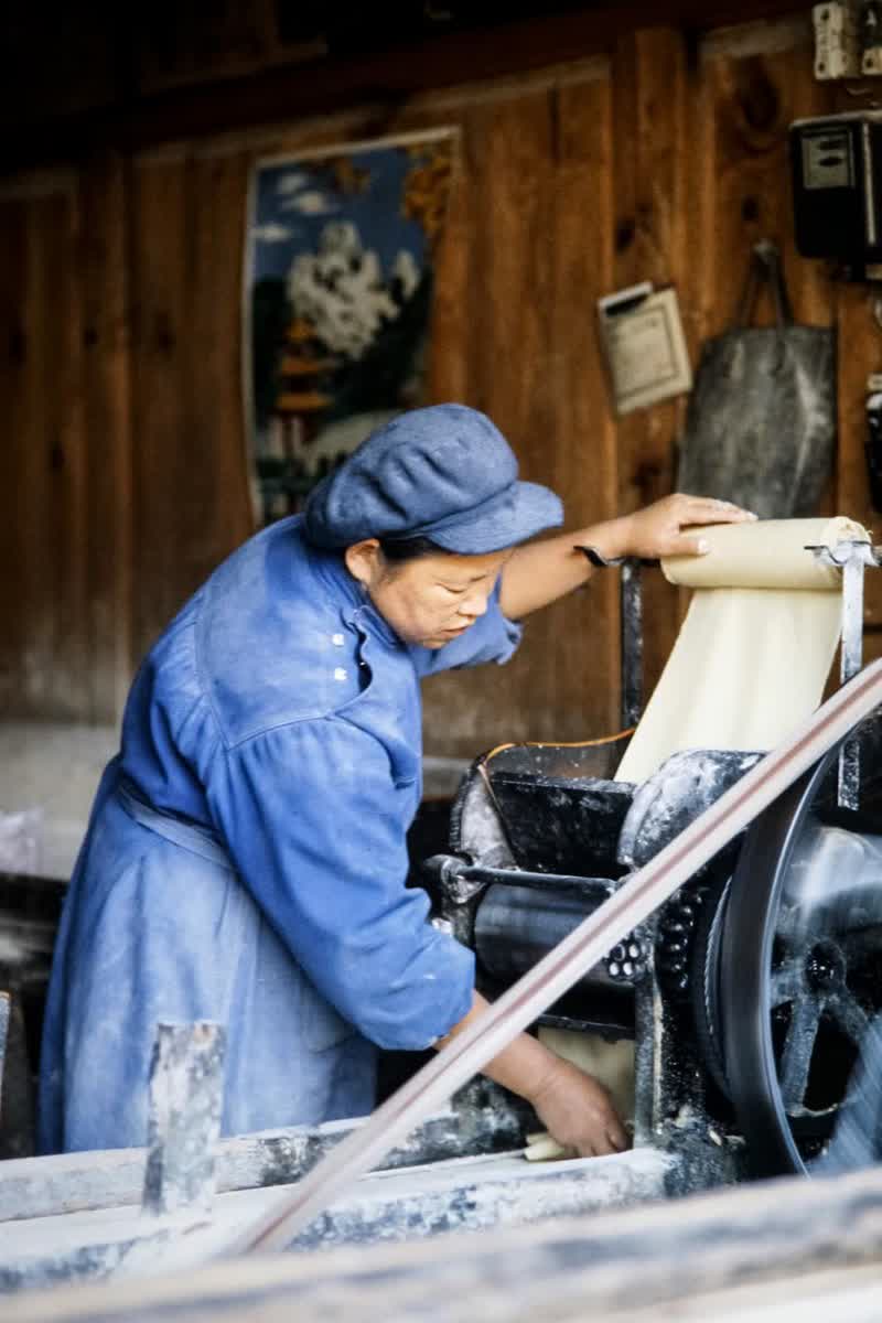 Chinese worker operating production equipment